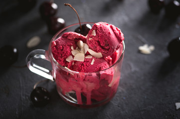 Homemade cherry sorbet with fresh berries on dark background