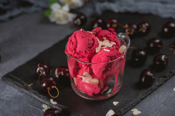 Homemade cherry sorbet with fresh berries on dark background
