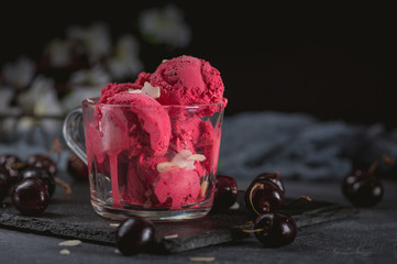 Homemade cherry sorbet with fresh berries on dark background