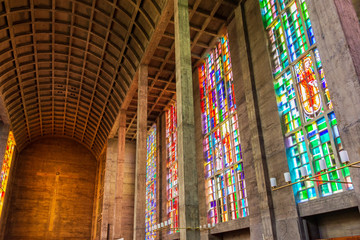Fototapeta na wymiar Interior view of nave inside St. Anthony Church, renown Brutalism and Cast in place concrete architecture designed by Swiss architect, and colourful stained glass windows in Basel, Switzerland.
