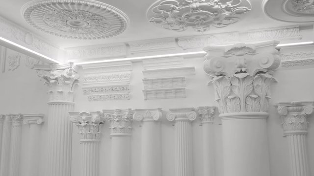 Decorative item made of white plaster on ceiling and wall. Beautiful ornament and relief stucco interior