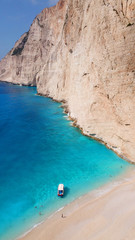 Fototapeta na wymiar Aerial drone view of iconic beach of Navagio or Shipwreck voted one of the most beautiful beaches in the world with deep turquoise clear sea, Zakynthos island, Ionian, Greece