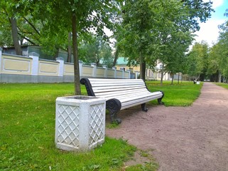 A bench for rest and trash container on a city street. The concept of cleanliness, ecology and comfortable urban environment. Cityscape.