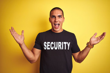 Young safeguard man with security t-shirt over yellow isolated background very happy and excited,...