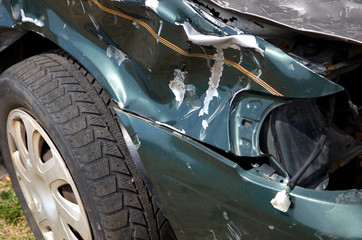 Badly Damaged Green Car Involved in an Automobile Accident