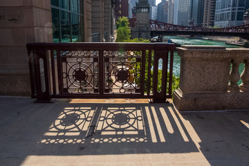 Shadows create patterns on sidewalk from bridge architecture