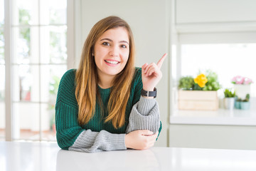 Young beautiful plus size woman wearing casual striped sweater with a big smile on face, pointing with hand finger to the side looking at the camera.