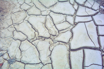 Fototapeta premium Dry mud ground, crack texture, granite gravel. Dry dirty soil. Cracks on clay