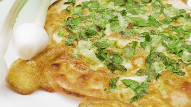 Onion pizza on white dish. National cuisine of Udmurts: The Tabani. Onion Feathers and Tortilla