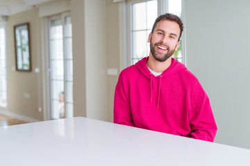 Fototapeta premium Handsome man wearing casual sweatshirt at home and smiling positive