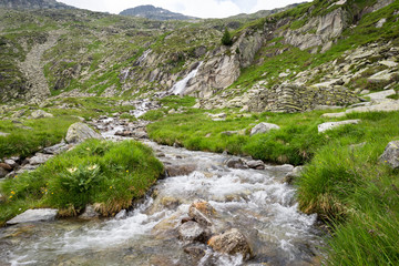 Wild flowing stream with several cascades in the mountains