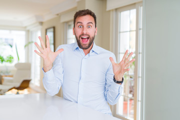 Fototapeta premium Handsome business man celebrating crazy and amazed for success with arms raised and open eyes screaming excited. Winner concept