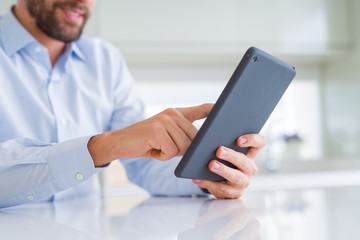 Close up of man hands using tablet and smiling