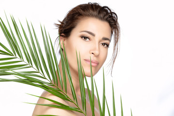 Fototapeta premium Beauty spa woman with green tropical leaf. Spa, skincare and wellness concept