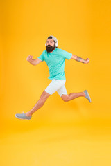 Fototapeta na wymiar Great music for dancing. Dancer man moving to music on yellow background. Bearded man enjoy jump dancing to modern music. Energetic hipster dancing with pleasure. Listening to dancing music