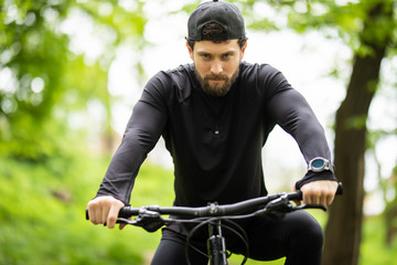 Handsome young man ride bike in the countryside