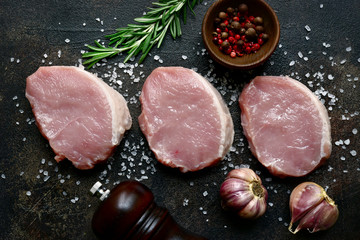 Slices of raw organic pork meat with ingredient for making. Top view with copy space.