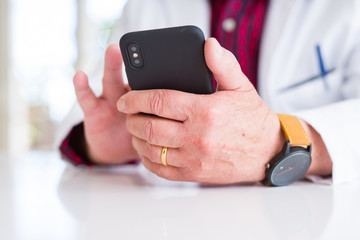 Close up of doctor hands using smartphone at the clinic