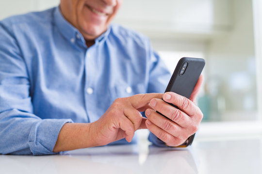 Close up of man hands using smartphone and smiling confident