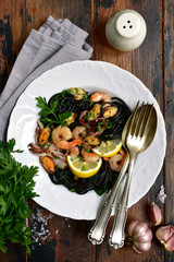 Black spaghetti pasta with seafood. Top view with copy space.