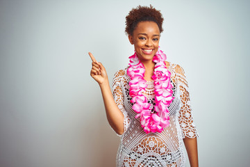 Young african american woman with afro hair wearing flower hawaiian lei over isolated background...