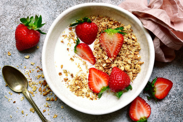 Homemade multicereal granola with yogurt and fresh strawberry for a breakfast.Top view with copy spoace.
