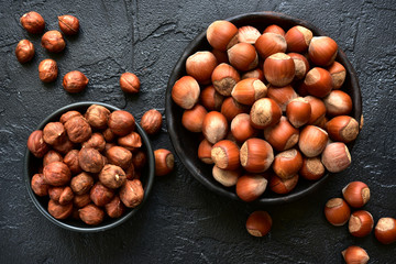 Peeled and unpeeled hazelnuts in a bowls.Top view with copy space.