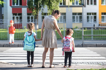 Back to school education concept with girl kids, elementary students, carrying backpacks going to class