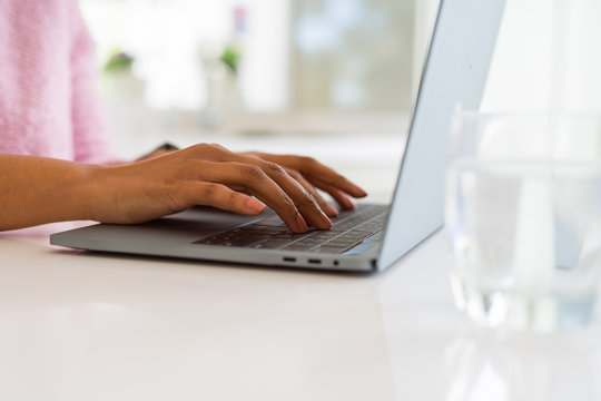 Close up of young woman working typing using laptop