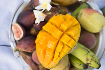 A plate of assorted fruits, sliced mango.