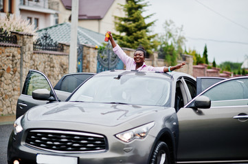 Rich business african woman in silver suv car on sunroof having fun with beer at hand.