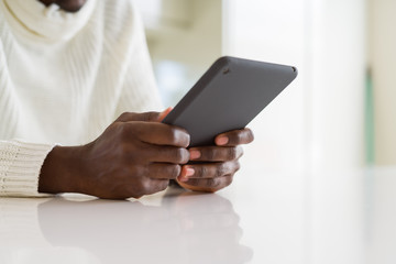 Close up of african business man using touchpad tablet, working sitting on a desk