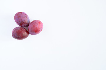 Several fresh ripe plums on white background