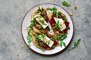 Healthy toasts with beetroot, feta cheese, nuts and arugula.Top view with copy space.