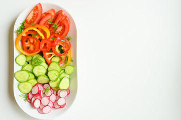 Fresh salad in a white plate. Cut vegetables. Top view.