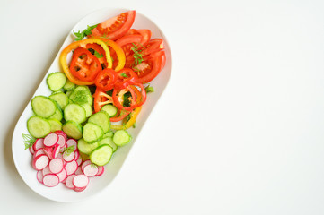 Fresh salad in a white plate. Cut vegetables. Top view.