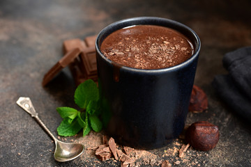 Homemade hot chocolate with mint in a black mug.
