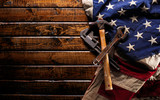 Old and worn work tools on large American flag - Labor day background