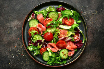 Vegetable salad with salmon and salad leaves mix. Top view with copy space.
