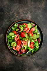 Vegetable salad with salmon and salad leaves mix. Top view with copy space.