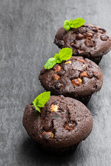 Triple chocolate muffins on black stone backgroung