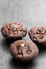 Triple chocolate muffins on black stone backgroung