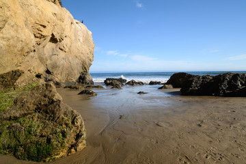 ocean waves on rock in El Matador Beach, Malibu with a sunny blue day in summer time