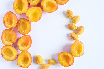 Several fresh ripe plums cut in half on white background