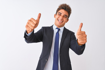 Fototapeta na wymiar Young handsome businessman wearing suit standing over isolated white background approving doing positive gesture with hand, thumbs up smiling and happy for success. Winner gesture.