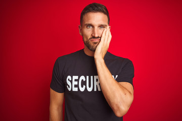 Young safeguard man wearing security uniform over red isolated background thinking looking tired...