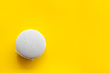 Wireless speaker as music gadgets on yellow background top view mock up