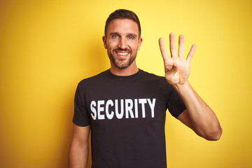 Young safeguard man wearing security uniform over yellow isolated background showing and pointing...