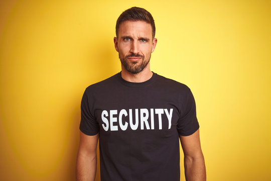 Young safeguard man wearing security uniform over yellow isolated background depressed and worry for distress, crying angry and afraid. Sad expression.