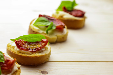 Tasty  bruschetta with sun-dried tomatoes on wooden table